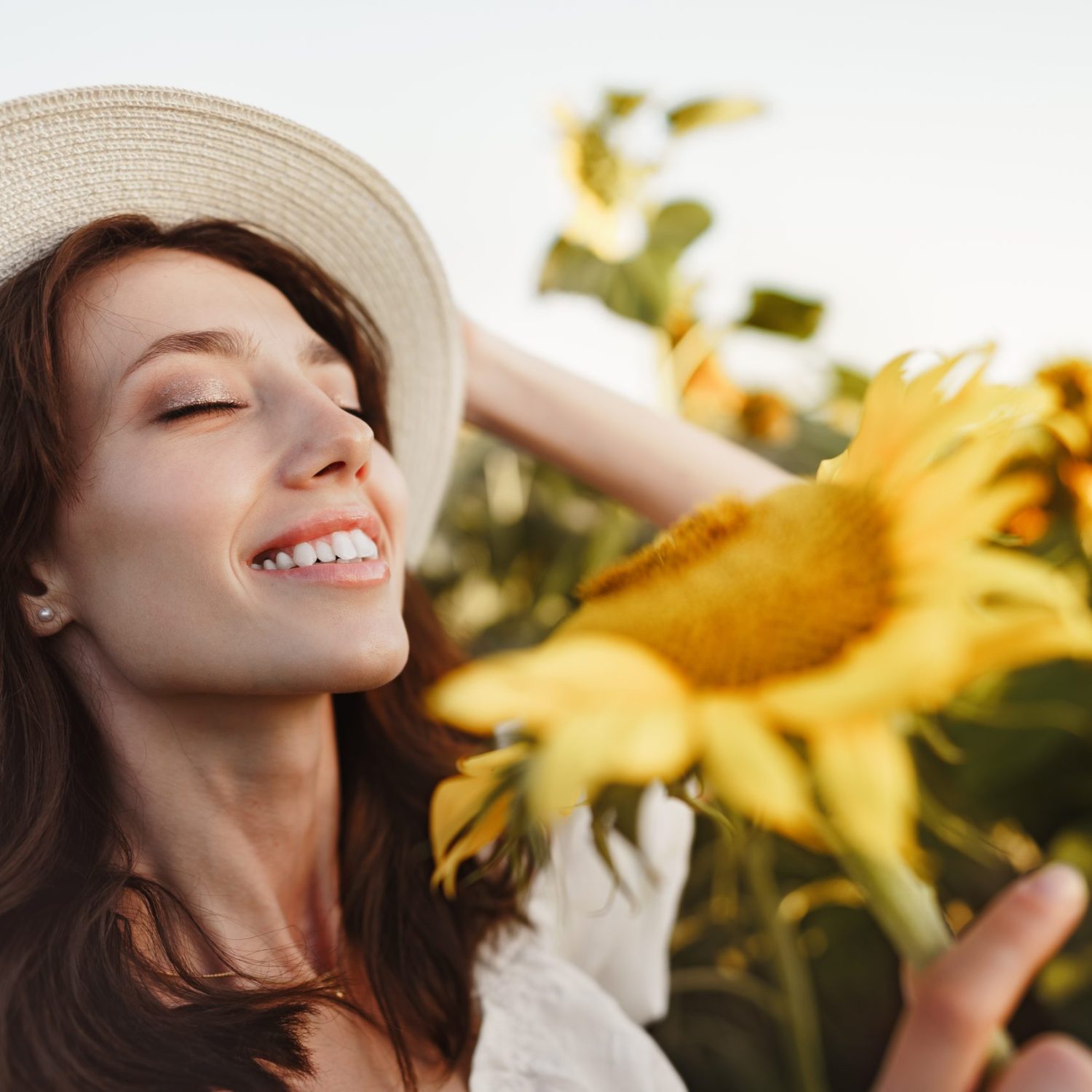 Attractive young woman model posing in field of sunflowers Attractive young woman model posing in field of sunflowers, close up